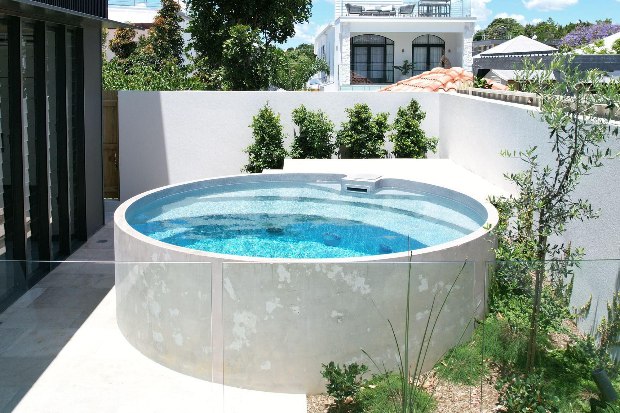 Plungie Arena, a circular plunge pool, in a Brisbane backyard. The pool is installed above ground, creating an architectural feature for this newly renovated space.